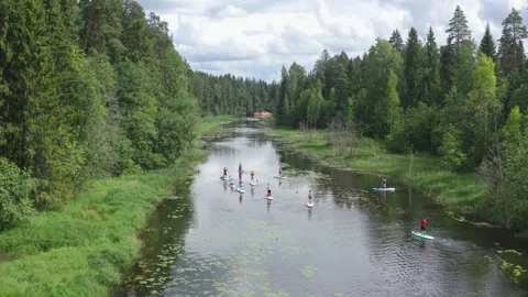 People on SUP boards riding down river Video stock 245364462