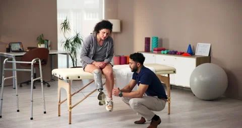 People, support and physiotherapy with prosthetic leg as amputee at wellness Stock Footage 283593663