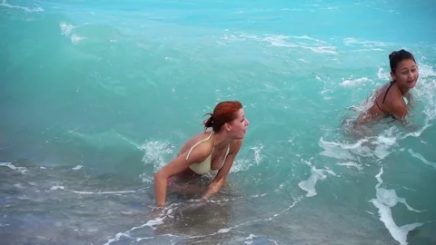 People in the surf have fun on the beach. Sea waves on the beach. Slow motion Stock Footage 82351273