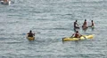 People on surfboard, kayak and boat at sea HD Footage