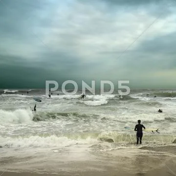 People Surfing In Stormy Ocean
