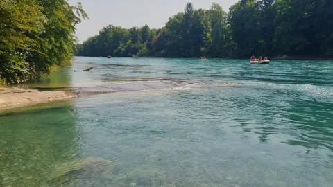 People swim and float in inflatable boats along the pristine Aare River in Bern Stock Footage 315513031