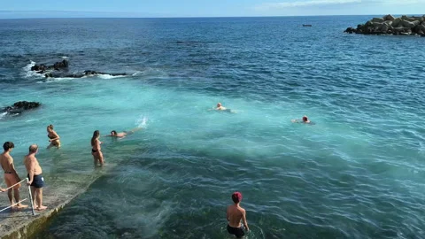 People swimming in Atlantic waves at the beach in Funchal, Madeira, Portugal, on Vídeo Stock 346247124