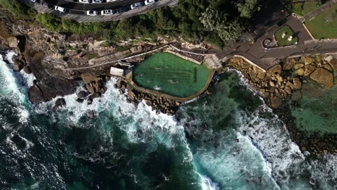People swimming in Bronte Baths ocean pool with waves crashing. From above. Stockbeeldmateriaal 168914415