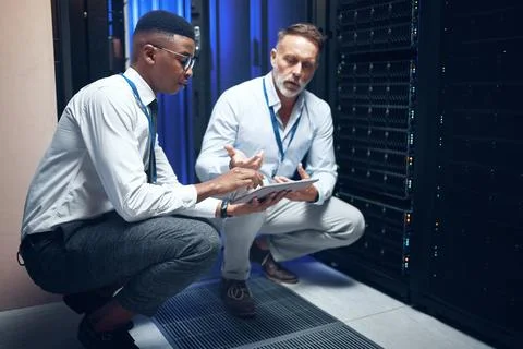 People, tablet or advice in server room for maintenance, problem solving or Stock Photos