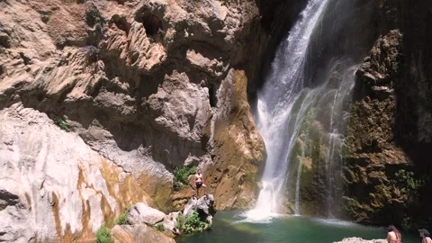 People take a bath under a waterfall during summer aerial drone view 動画素材 279570324