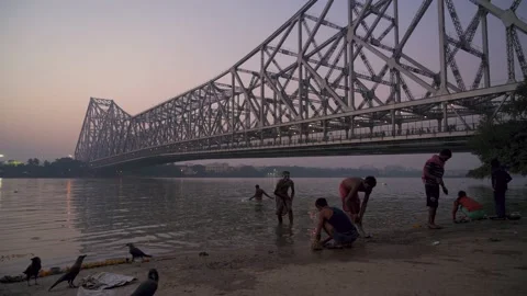 People taking bath in holy river Ganges near famous Howrah Bridge. Stock Footage 146050132