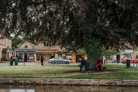 People taking a break under a tree by River Windrush in Bourton-on-the-Water, Stock Photos