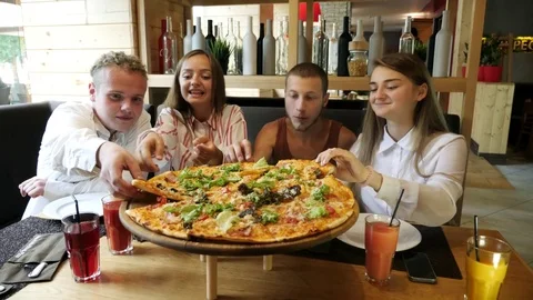 People taking pizza cuts from plate on table. Stock Footage 80644879