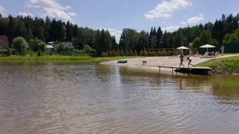 People taking rest at the beach area with sand and loungers near a small lake Stock Footage 148735784
