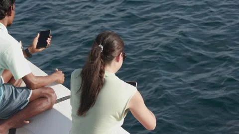 People taking video on phone while wild dolphins swim and play with bow Stock Footage 164232105