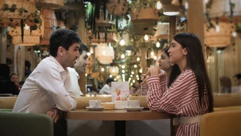 People talk at table in modern cafe with stylish interior Stock Footage 106328001