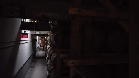 People talking in distillery with barrels of bourbon in the foreground Stock Footage 113752541