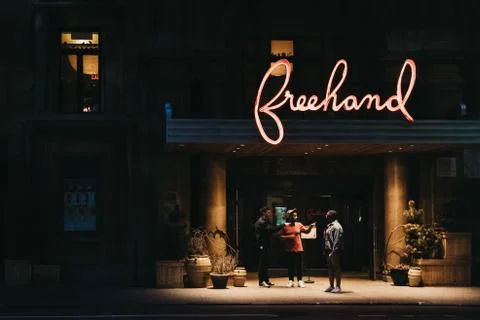 People talking under the illuminated sign of Freehand Hotel in Flatiron Distr Stock Photos