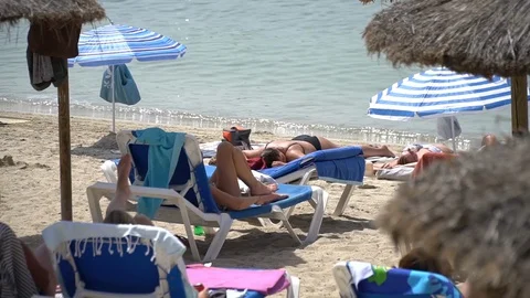 People tanning at the beach Stock Footage 128348198