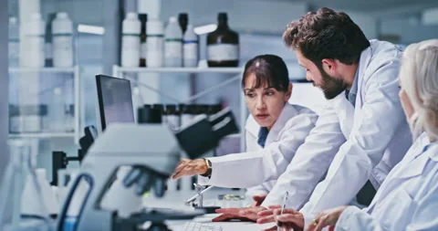 People, team and scientist with computer at lab, talk or point for review with Stock Footage 330080692