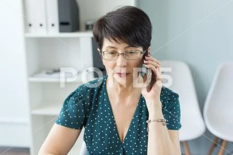 People, technology and communication concept - Middle aged business woman at Stock Photos