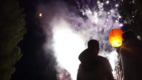 People with their backs to the camera are watching fireworks Stock Footage 163725420