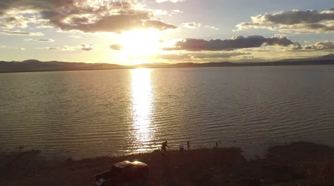 People Throwing Rocks in a Lake Stock Footage 63357403