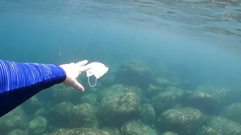 People throws out a medical face mask floating underwater on ocean water-Dan Stock Footage 134281453