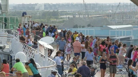People on top deck of cruise ship as it leaves port Stock Footage 87396029
