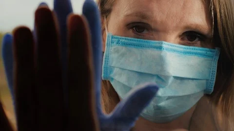 People touch their hands through the glass, a woman in a protective mask looks Stock Footage 130048742