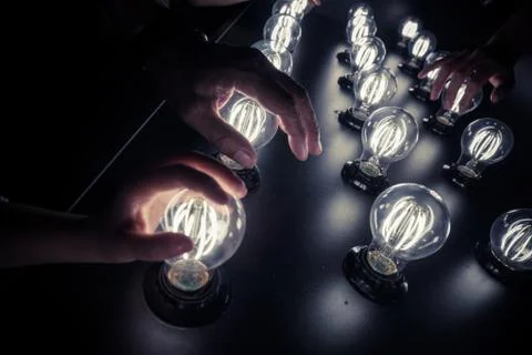 People touching light bulbs Stock Photos