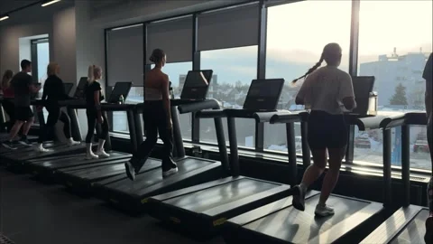 People training on treadmills in large modern gym hall Stock Footage 330135573