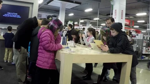 People trying new apple computer inside future shop Stock Footage 45706376