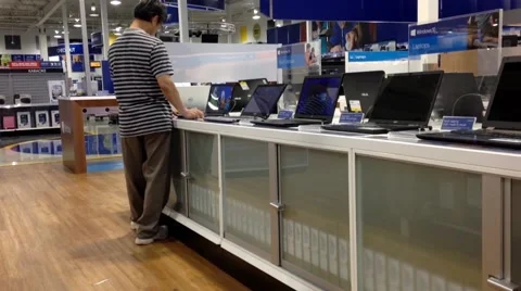 People trying new computer inside store Stock Footage 54975357