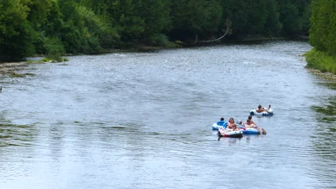 People In Tubes Flowing Down Nice River Together In the Late Afternoon Light Stock Footage 200858498