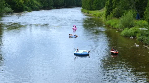 People In Tubes Flowing Down Nice Rural River In the Late Afternoon Light Stock Footage 200858663