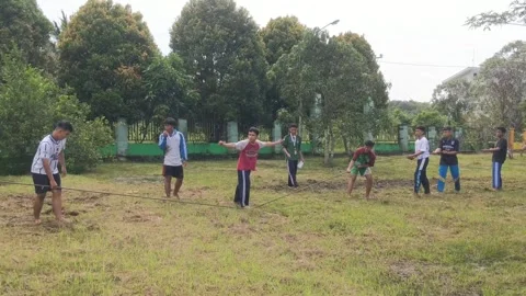 People in two teams in a tug-of-war competition to celebrate 79 years Stock Footage 282229166