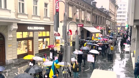 People with Ukrainian flags and posters PUTIN MURDERER and STOP WAR walking Stock-Footage 194762695