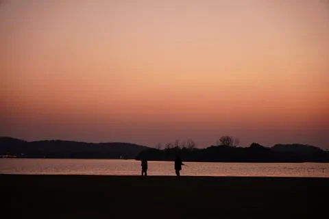 People under sunset, in the shadow Stock Photos