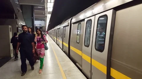People at underground subway metro platform, train leaves station, Delhi, India Stock Footage