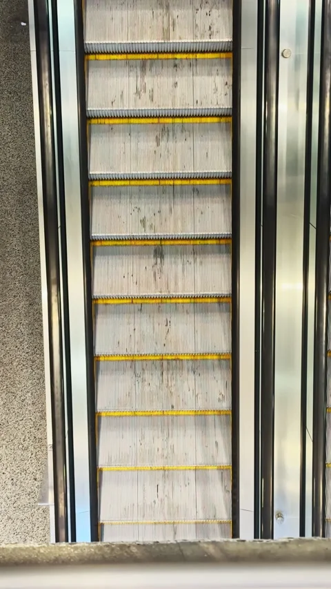People use escalator to move between floors in a building during daytime hours Stock Footage 332272837