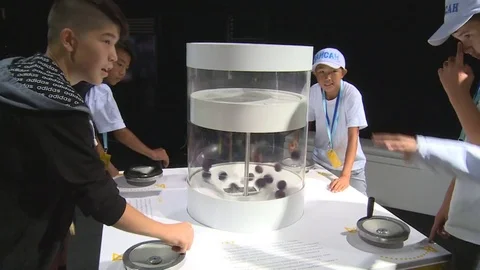 People use handle in interactive exposition stand showing molecules movement Stock Footage 78707124