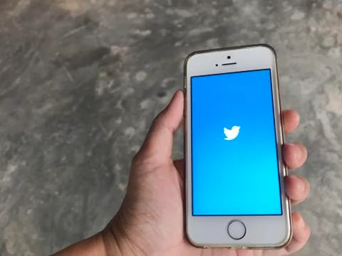 People uses twitter application in iphone se mobile Stock Photos