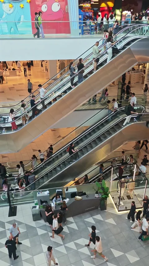 People using escalators in a busy shopping mall 库存影片 315358975