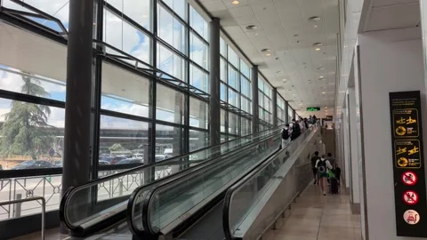 People using a moving walkway inside Madrid Barajas Airport terminal Видео 344584321