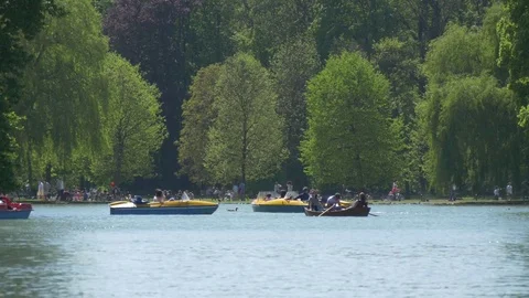 People using paddle boats on the pond at English Garden in Munich 스톡 동영상 75951635