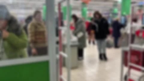 People using self-service checkouts in a modern supermarket. Shoppers with bags 库存影片 329162418