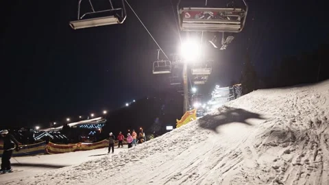 People using ski chair elevator to travel around mountains. People on background Stock Footage 148976191
