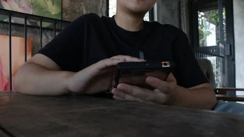 People using smartphone at coffee shop Stockbeeldmateriaal 105582611