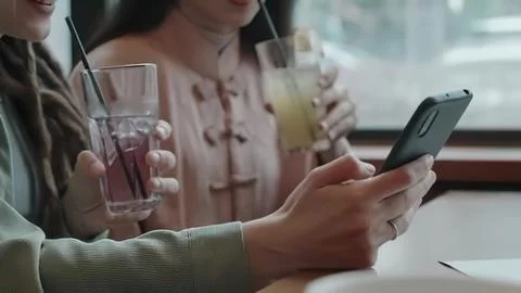 People using smartphones and drinking drinks at a cafe Stock Photos