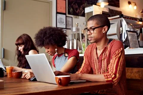 People using technology in coffee shop 库存照片