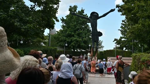 People venerating the statue of the Risen Christ in Medjugorje. Stock Footage 283594875