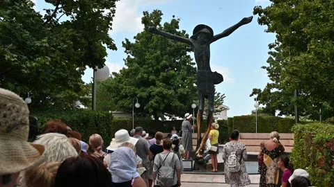 People venerating the statue of the Risen Christ in Medjugorje. Stock Footage 283594946