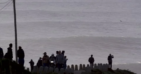 People on viewpoint looking at stormy ocean and moving waves in slow motion Stock Footage 149934828